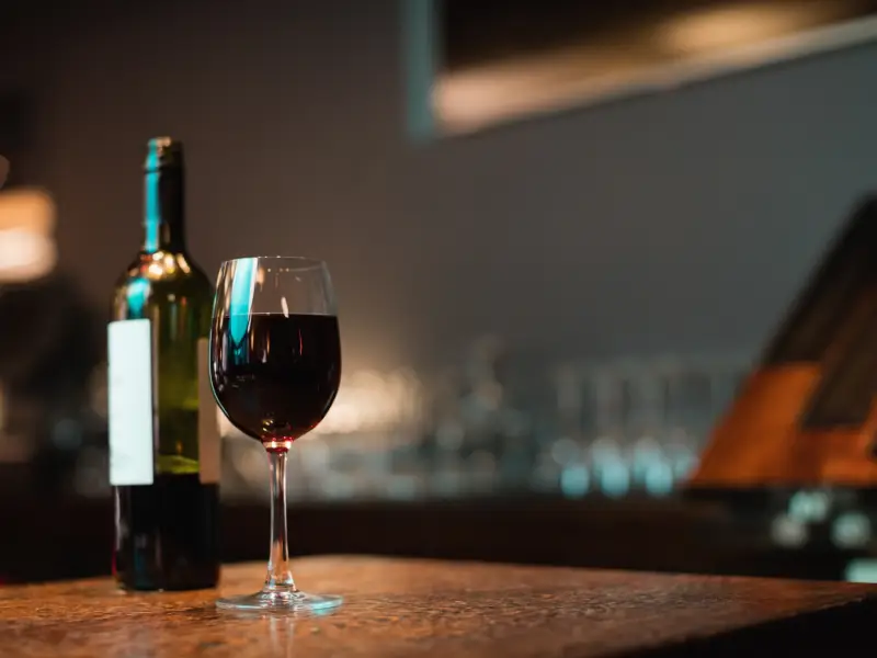 Glass of red wine with bottle at Leblon Churrascaria bar