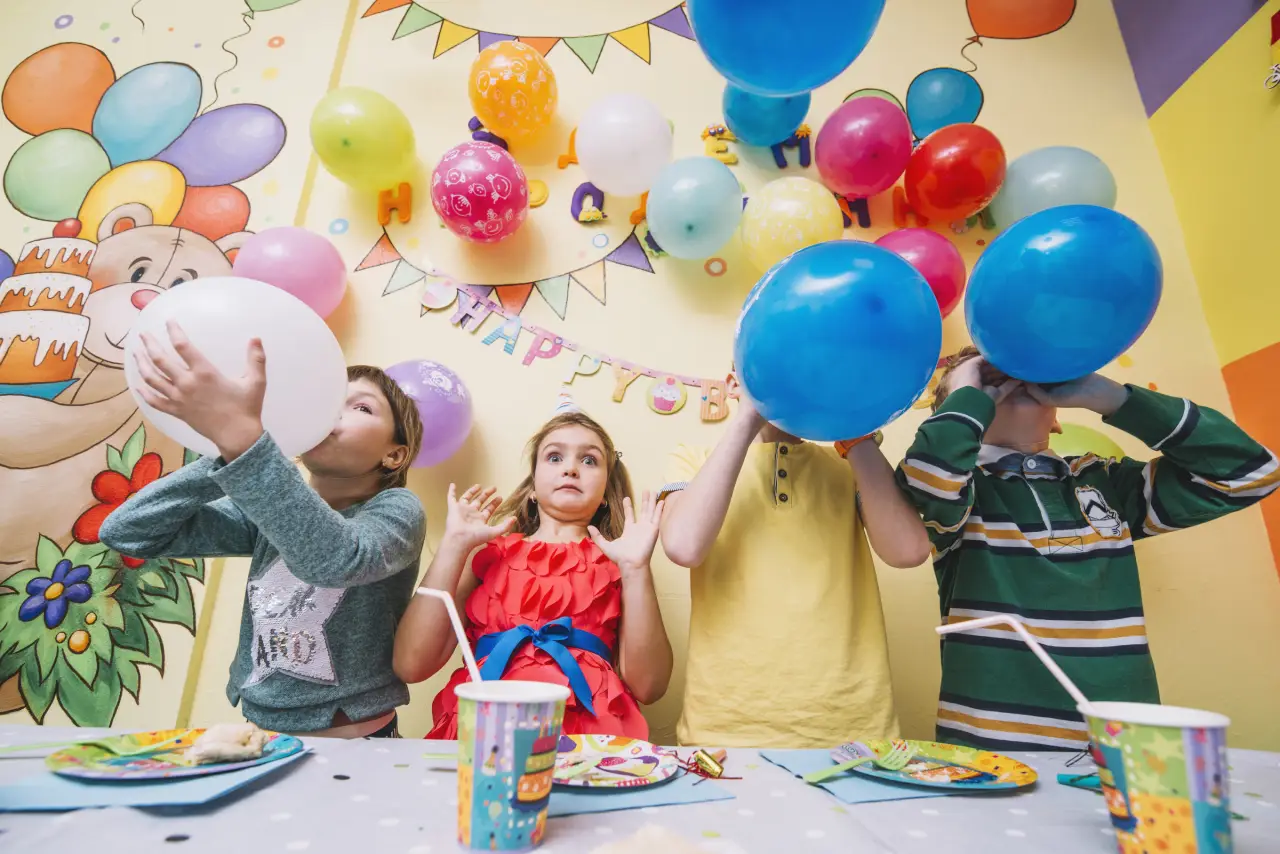 Children celebrating birthday party with balloons