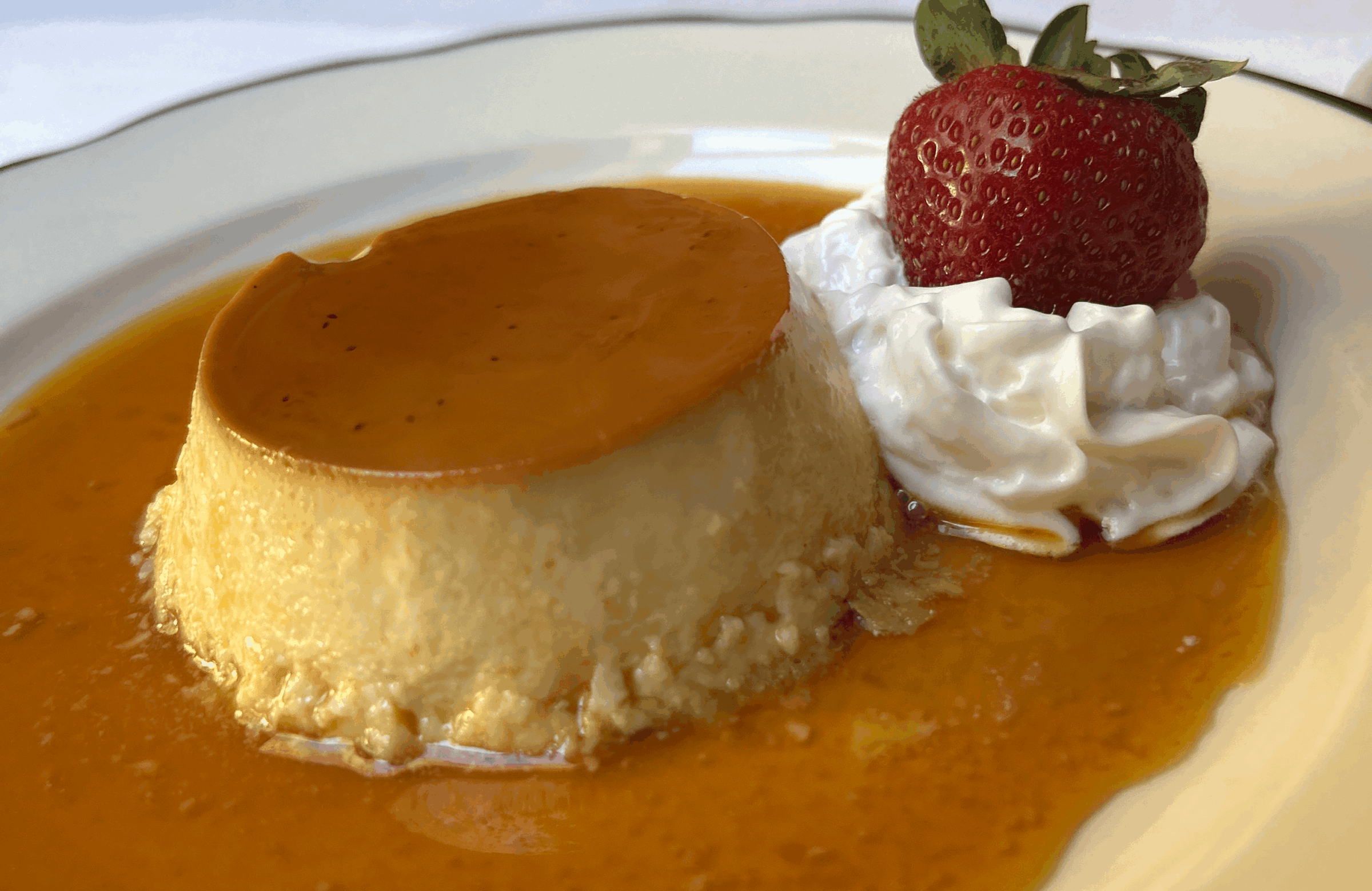Flan, Brazilian condensed milk custard with caramel, strawberry, and whipped cream