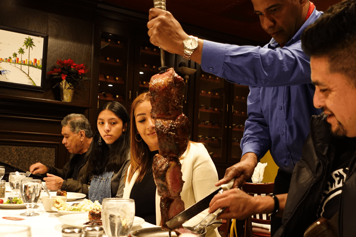 Gaucho chef carving fire-roasted meat tableside at Leblon Churrascaria