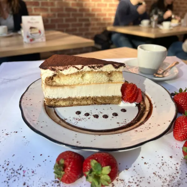 Slice of tiramisu cake with strawberries and espresso